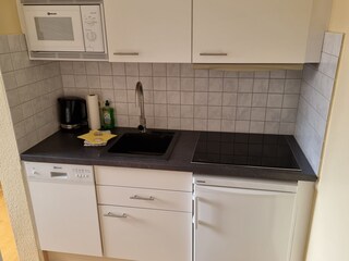 Küchenzeile mit Spülmaschine, Mikrowelle und Kühlschran