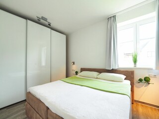 Schlafzimmer  Doppelbett, Kleiderschrank und großem  Fenster