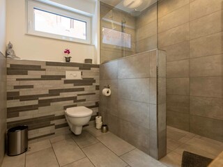 Badezimmer mit begehbarer Dusche und Fußbodenheizung