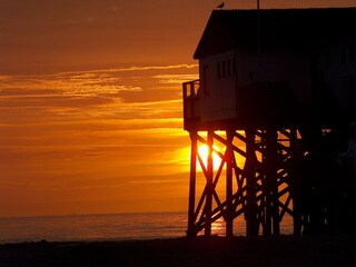 Pfahlbau am Strand und Sonnenuntergang