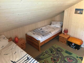 Schlafzimmer mit zwei Einzelbetten im OG