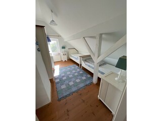 Schlafzimmer 2 mit zwei Einzelbetten und Kinderbett