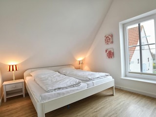 Das große Fenster im Schlafzimmer versorgt den Raum mit viel Tageslicht.