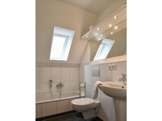 Das Badezimmer im DG verfügt über eine Badewanne.