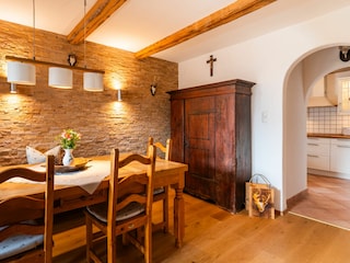 Esszimmer mit antikem Bauernschrank und Blick zur Küche