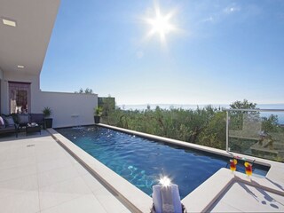 Der Pool mit Sonnenliegen und Meerblick