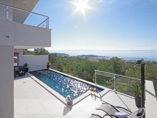 Der Pool mit Sonnenliegen und Meerblick