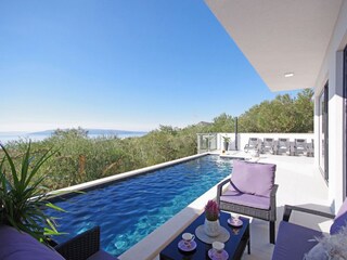 Der Pool mit Sonnenliegen und Meerblick