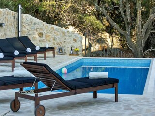 Der Pool mit Sonnenliegen und Aussendusche