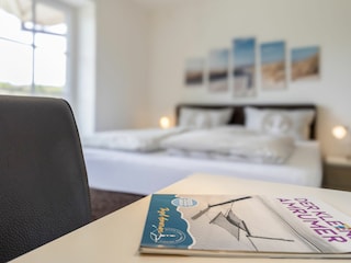 Schlafzimmer mit Boxspringbett und Zugang zum Balkon