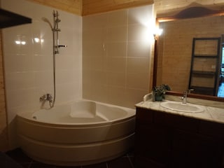 Ground floor bathroom with bathtub, washing machine, and toilet
