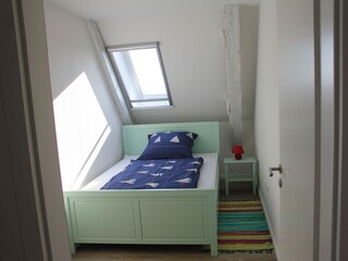 Schlafzimmer mit großem Einzelbett (ca. 140 x 200)