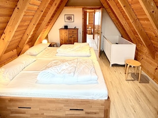 Schlafzimmer mit Doppelbett und Kinderbett