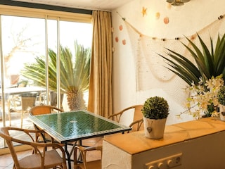 Veranda mit großer Glasfront zum Sandstrand