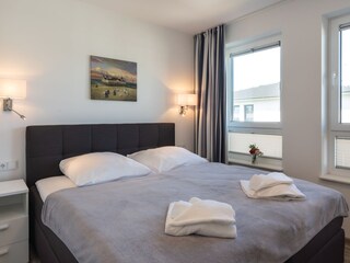 zweites Schlafzimmer mit Boxspringbett und TV