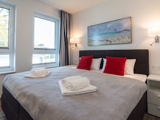 zweites Schlafzimmer mit Boxspringbett und TV
