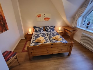 Das Schlafzimmer mit dem Schreibtisch.