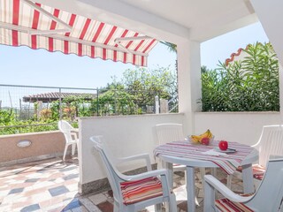 überdachte Terrassensitzgruppe mit Sonnenschutz