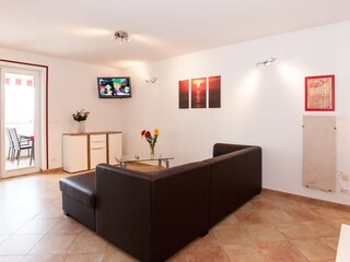 großer Wohnraum mit Funktionssofa und Fernsehecke