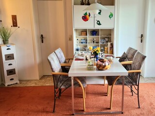 Dining table in the living area, upholstered chairs