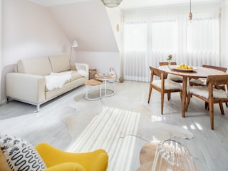 Wohnzimmer mit Schlafsofa und Esstisch.