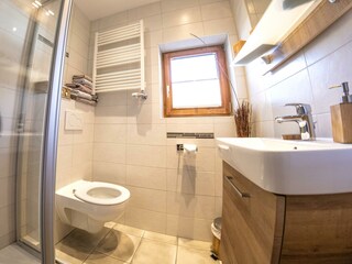 Bad mit Dusche, WC und Waschbecken.