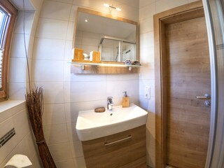 Bad mit Dusche, WC und Waschbecken.