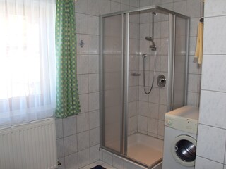 Shower with washing machine on the ground floor.