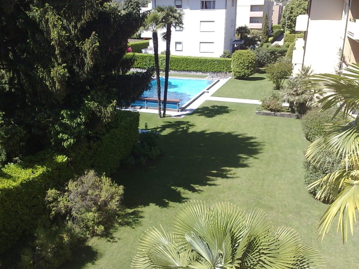 Blick vom Balkon: Pool + Garten