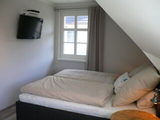 ...das große Schlafzimmer mit Flachbildschirm