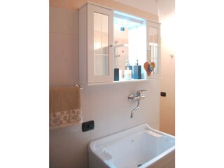 zweite Badezimmer mit Waschmaschine und Dusche