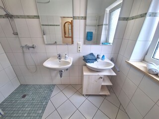 Badezimmer mit ebenerdiger Dusche und Fenster