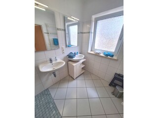 Badezimmer mit ebenerdiger Dusche und Fenster