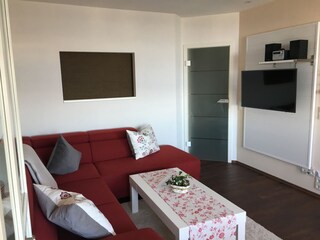 Komfortsofa und Fernsehwand mit Mini-HiFi-Anlage.