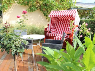 sonnige Terrasse mit Strandkorb