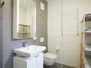 Badezimmer mit ebenerdiger Dusche und WC