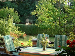 Terrasse mit Sonnenschirm, Stühlen und Liegen