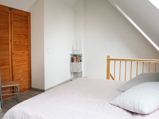 Schlafzimmer mit offener Treppe zum Wohnbereich