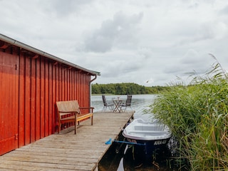 Steg mit Badeleiter und hauseigenem Boot