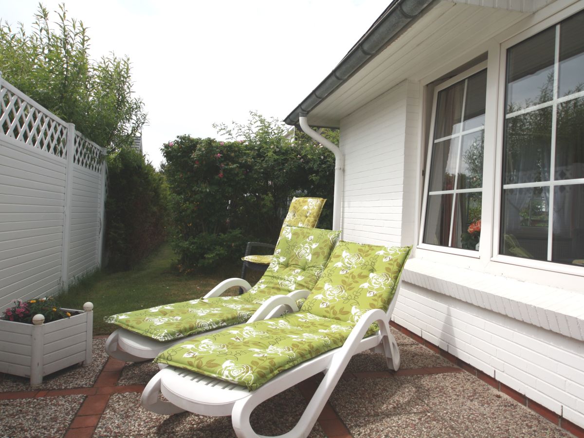 Terrasse mit Sonnenliegen und Gartenmöbeln