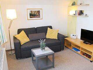 mit Couch, Sessel und Flachbild-TV