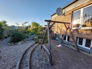 Sicht- und windgeschützte tiefeSüdterrasse mit Schaukel