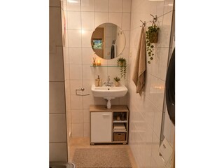 Badkamer met wasmachine en droger.