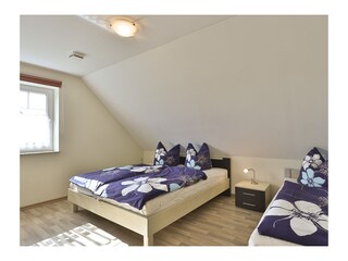 Schlafzimmer mit Dooppelbett und Einzelbett