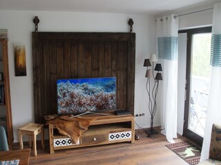 Wohnzimmer mit Zugang zum Balkon, großer TV