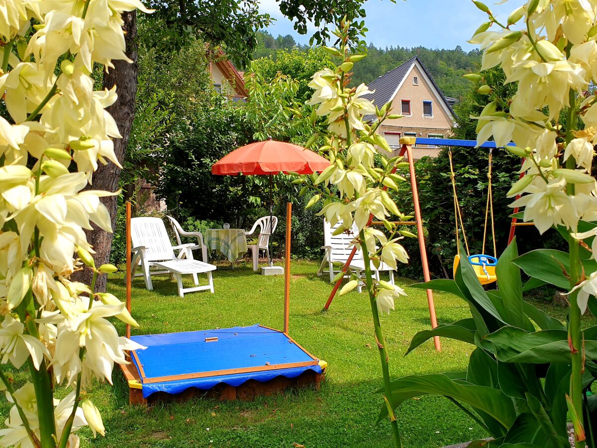 Garten mit Sonnenliegen, Sandkasten und Schaukel