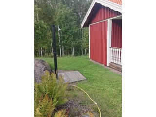 einfache einfache Außendusche neben der Sauna