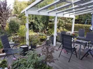 überdachte Terrasse mit Blick in den Garten