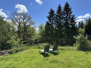 umzäunter Garten mit Sonnenliegen
