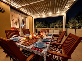 Die großzügige, überdachte Terrasse lädt zu einem stimm
